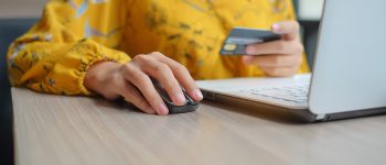 Asian woman holding credit card and using laptop for online shopping while making orders. internet, technology, ecommerce and online payment concept
